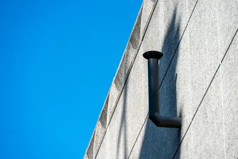 Exhaust pipe on a concrete wall